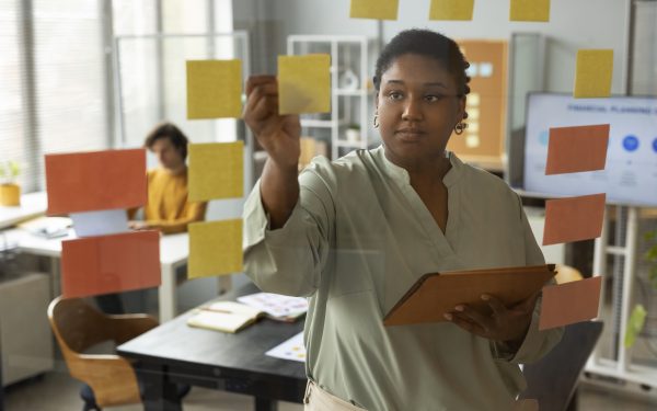 Woman adding change management notes to a wall